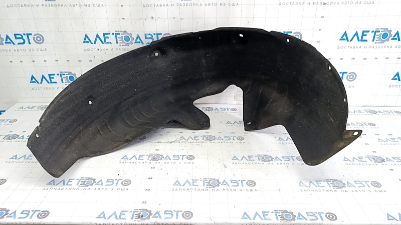 The rear left fender liner of a Kia Sportage 23-26 has a torn fastener.