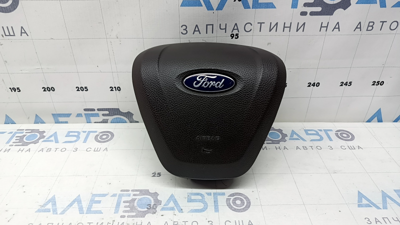 The steering wheel airbag for the driver's side of a Ford Fusion mk5 17-20 is brown and scratched.