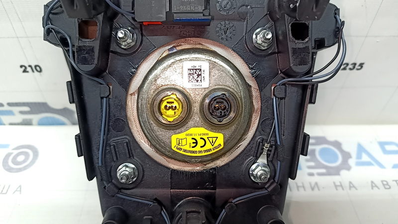 The steering wheel airbag for the driver's side of a Ford Fusion mk5 17-20 is brown and scratched.