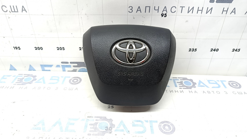 The Toyota Highlander 20-22 driver's steering wheel airbag is black and scratched.