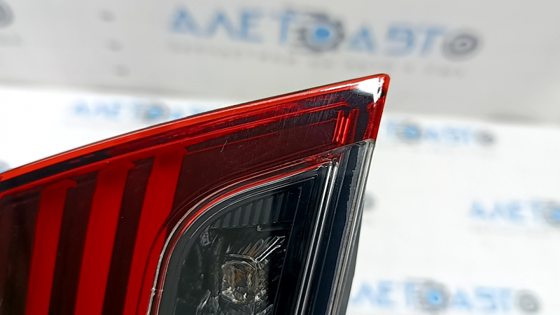 The inner taillight of the left Lexus ES 19-26 trunk lid is chipped, there are cracks in the glass, and the fasteners are broken