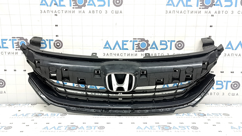 The base of the radiator grille of the Honda Accord 16-17 hybrid, with the emblem, is cracked, the fastener is broken