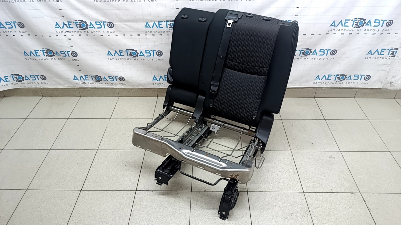 The back of the rear row of seats, 2nd row, left, Nissan Rogue 17-20, black fabric, with a belt, armrest and lower frame, is wrinkled