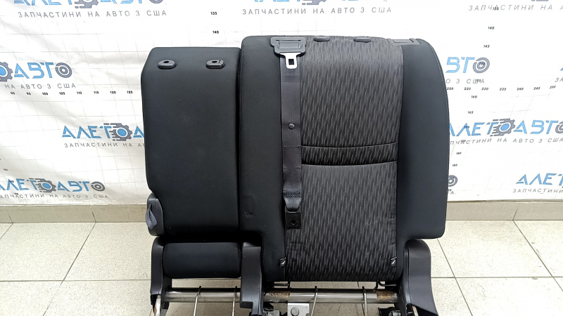 The back of the rear row of seats, 2nd row, left, Nissan Rogue 17-20, black fabric, with a belt, armrest and lower frame, is wrinkled