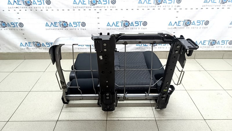 The back of the rear row of seats, 2nd row, left, Nissan Rogue 17-20, black fabric, with a belt, armrest and lower frame, is wrinkled