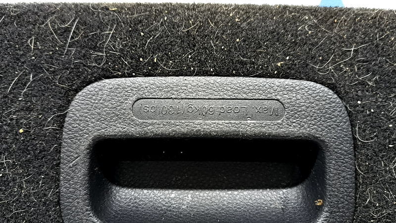 The trunk floor of the Kia Niro 17-22 HEV is black, under the tray, in need of cleaning, scratches on the handle