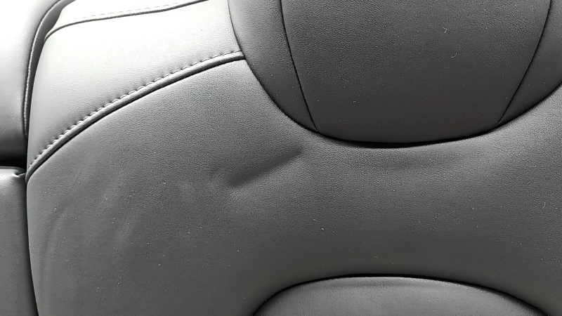 The back of the rear row of seats, left, Tesla Model 3 18-23, black leather, with a belt and heating, is wrinkled