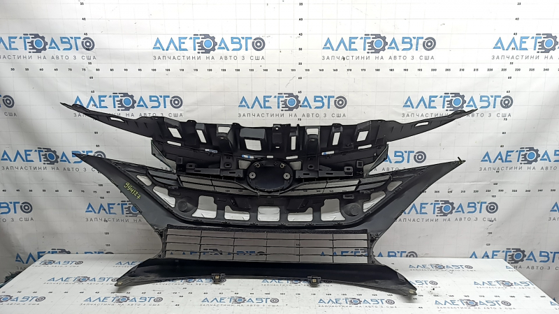The radiator grille assembly for a Toyota Prius 50 Prime 17-19 with an emblem, under a radar, without parking sensors, cracked, chipped, and a broken mount