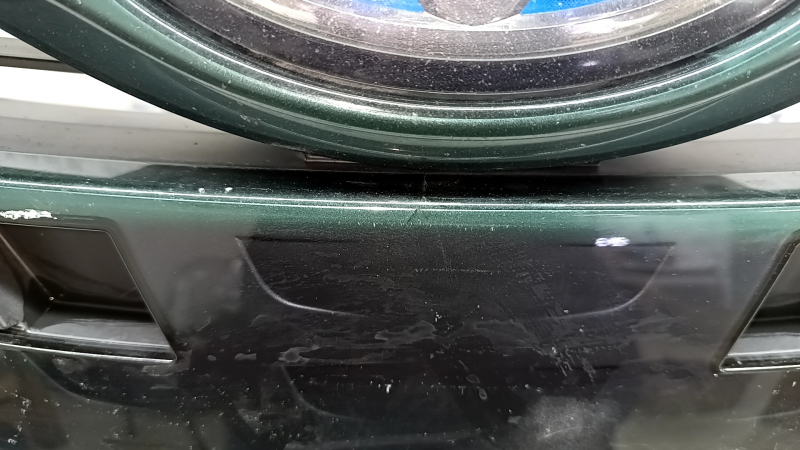 The radiator grille assembly for a Toyota Prius 50 Prime 17-19 with an emblem, under a radar, without parking sensors, cracked, chipped, and a broken mount