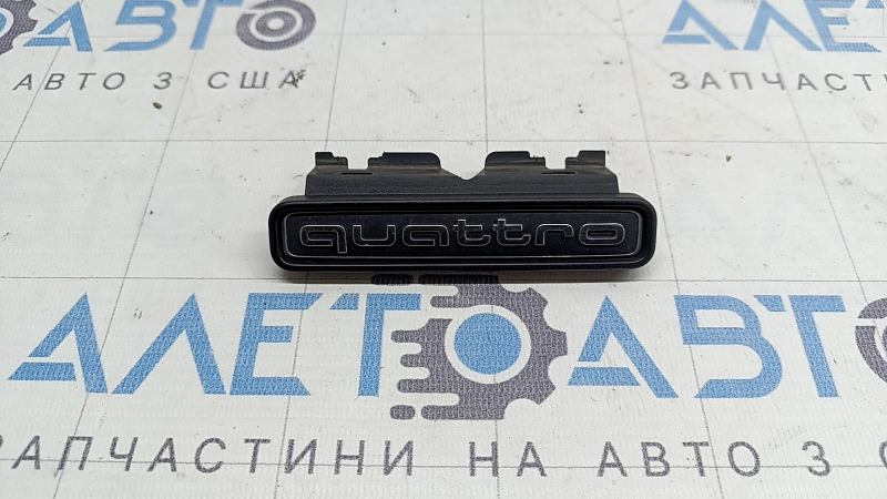 Emblem with the inscription "quattro" on the radiator grille of the Audi A4 B9 20-25