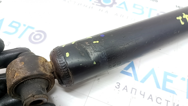 The rear left shock absorber of Toyota Prius 30 10-13 is dented and rusty